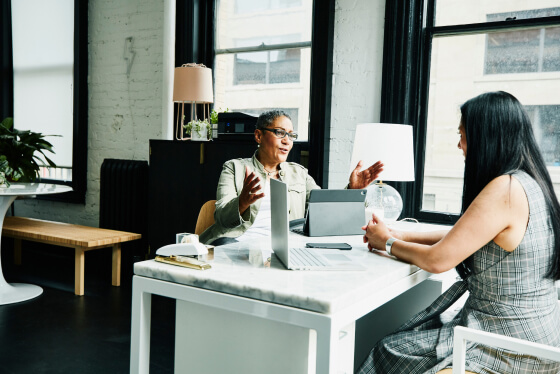 Two women in an office discussing wealth management
